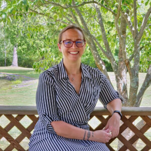 Portrait of a woman sitting outside on a bench.