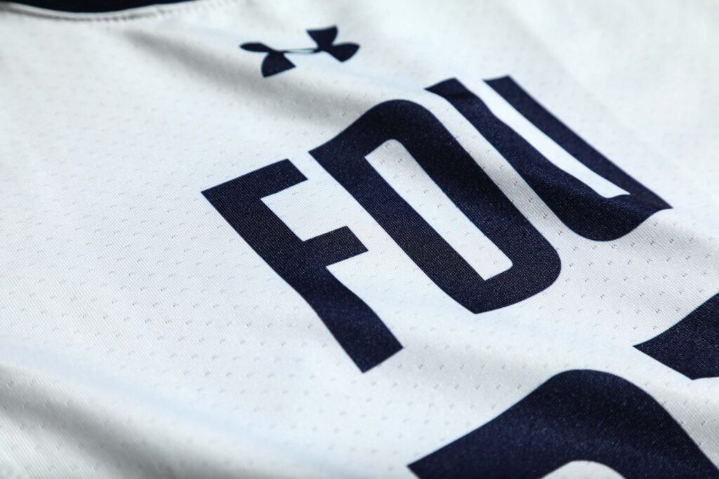 A white and blue athletic jersey that reads FDU worn during the winter and spring athletic seasons. 