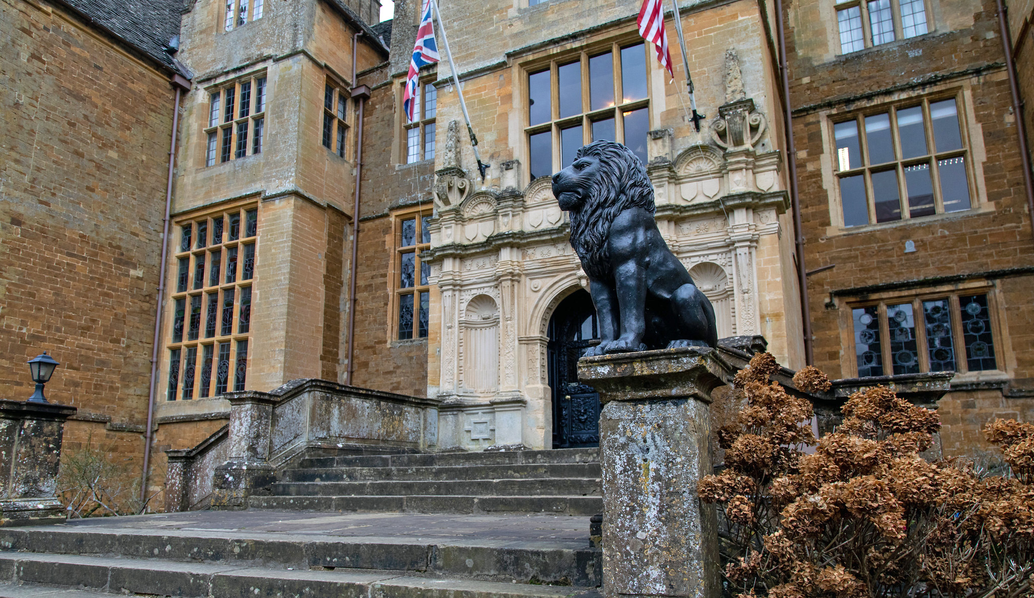 A lion sculpture sits atop a pillar near the entrance of Wroxton Abbey.