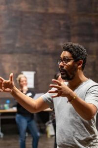 A man gestures in a theater class