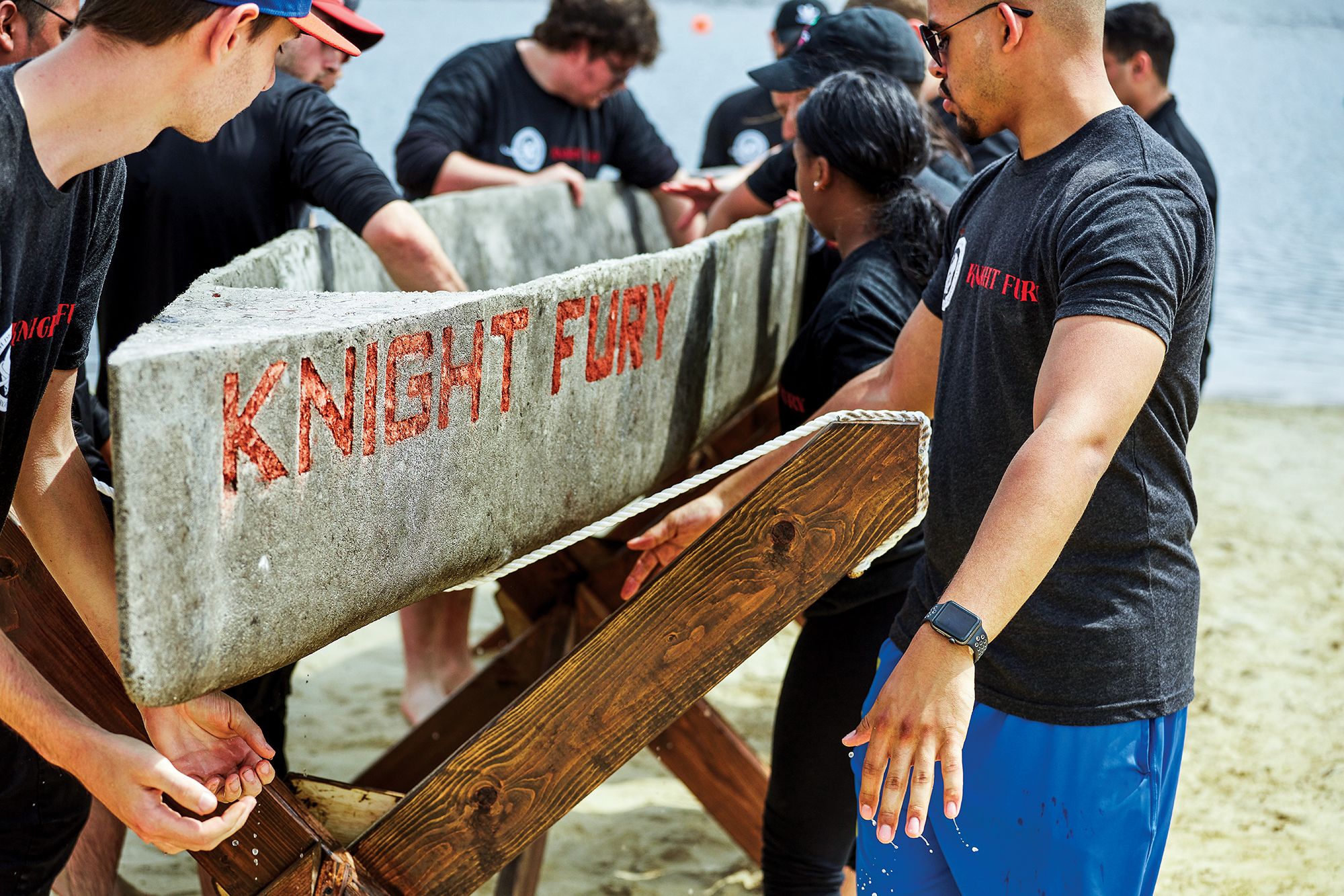 A team of engineering students prepare to lift and launch a concrete canoe.