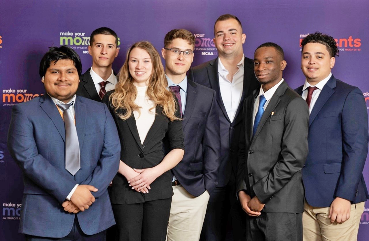 A group of seven smartly dressed students pose for a photo at the Mechanical Contractors Association of America's student competition. 