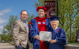 A professor, a college president and a 90-year-old graduate student smile for a photo.