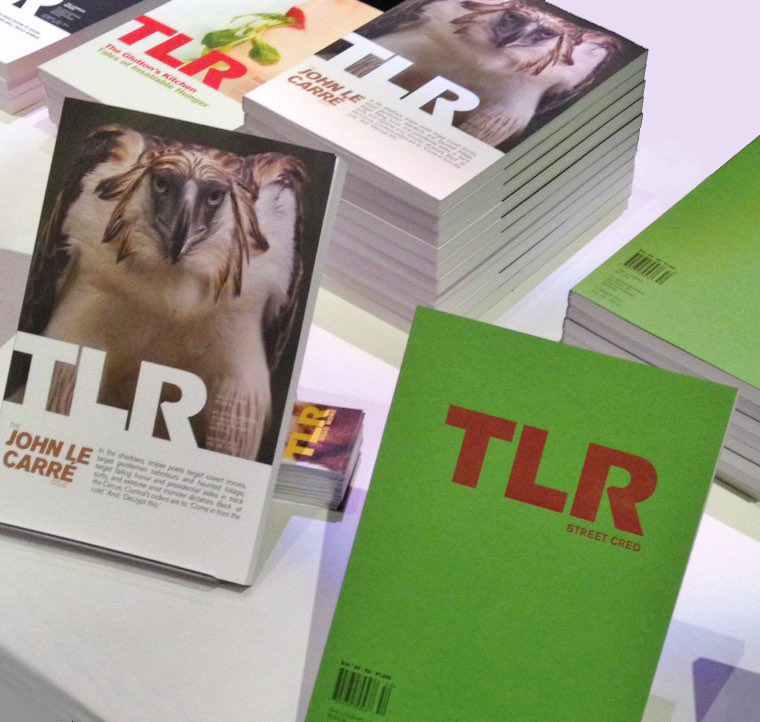 A table full of different issues of TLR, The Literary Review.