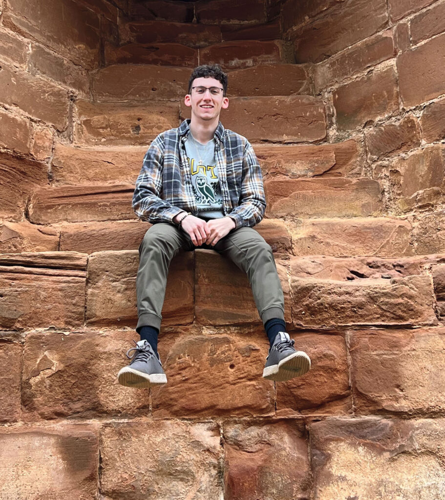 A man sits atop castle ruins.