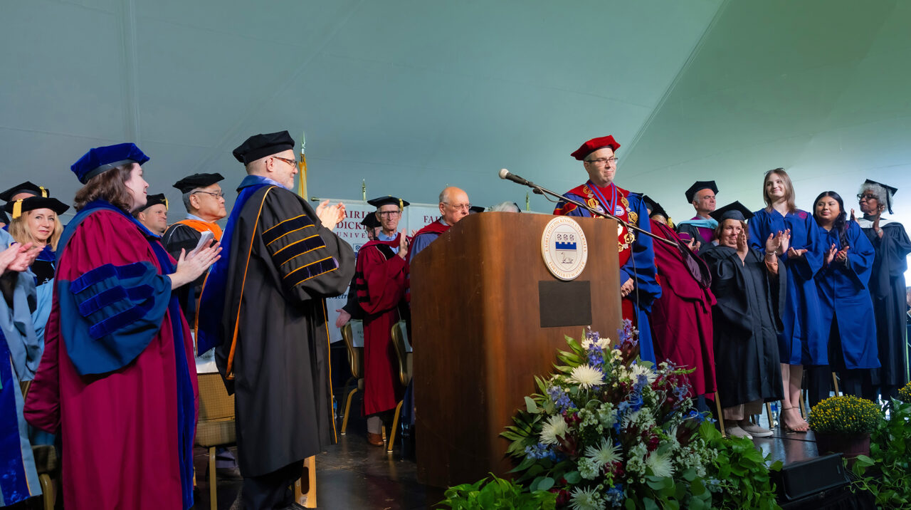 Academics in regalia on stage.