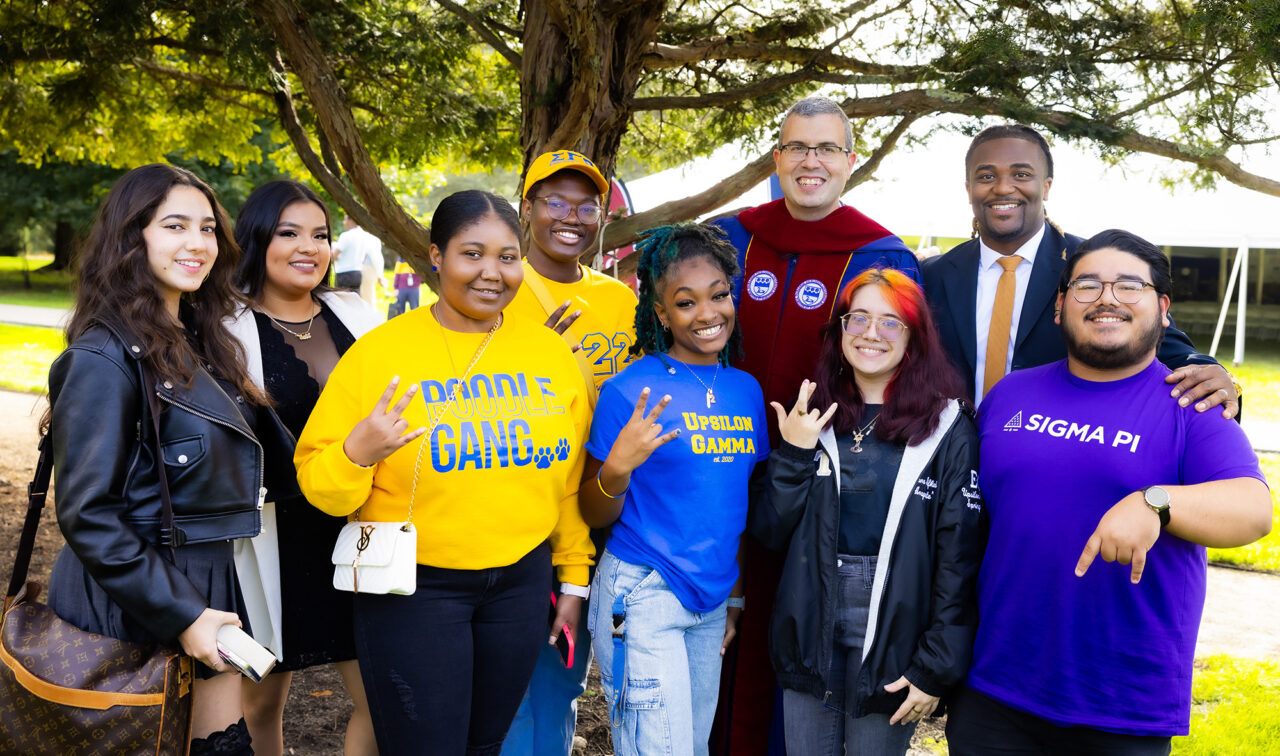 A group of students and adults pose for a photo.