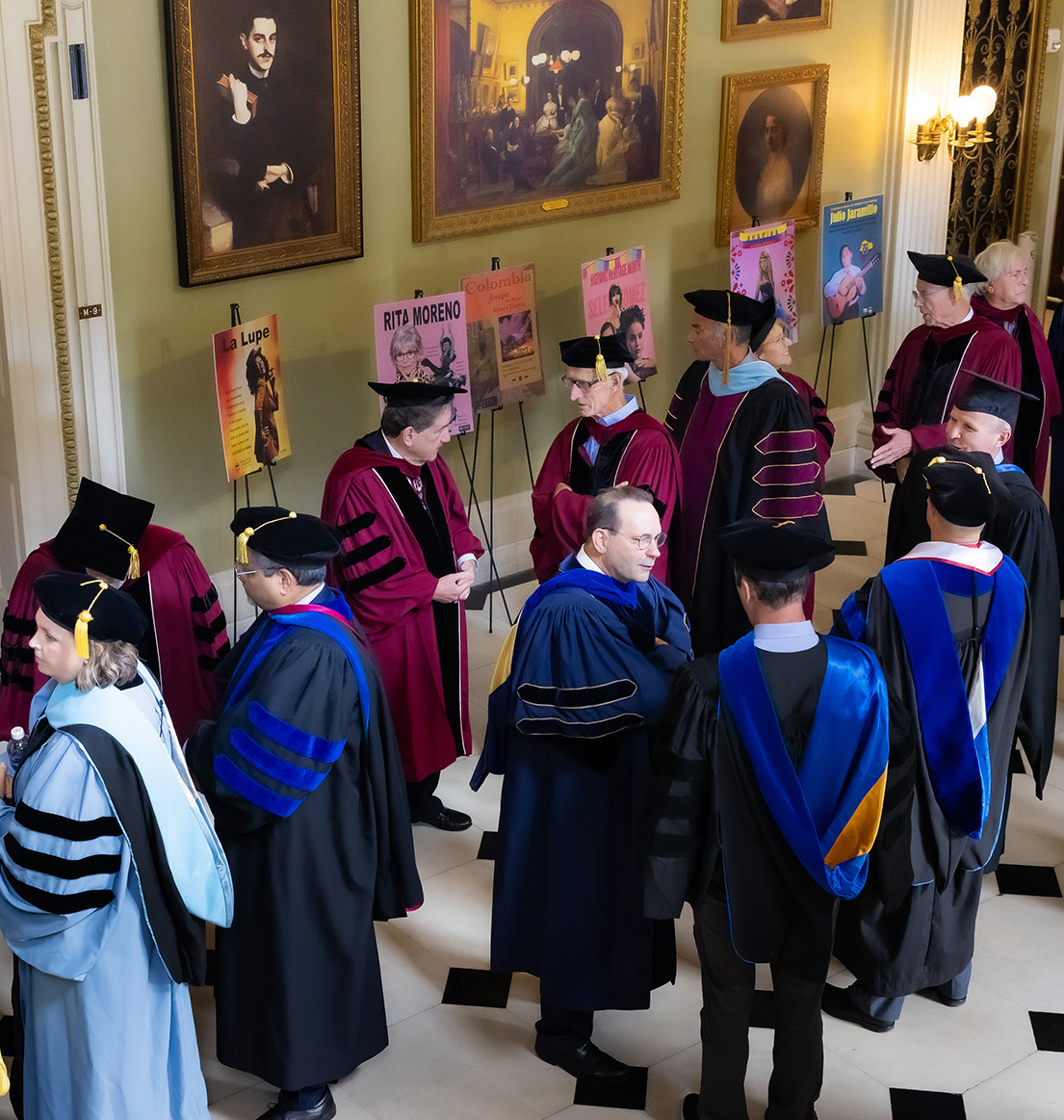 Faculty and administrators dressed in academic regalia mingle as they wait for convocation and inauguration to begin.