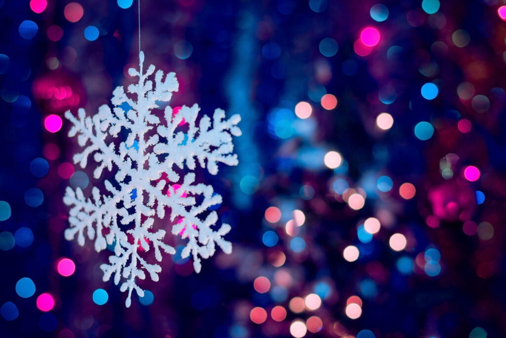 A snowflake in front of a blurred colorful background