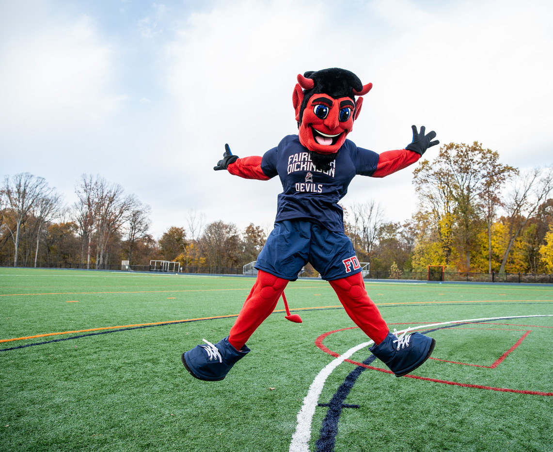 The Devil mascot leaps into the air on the field.