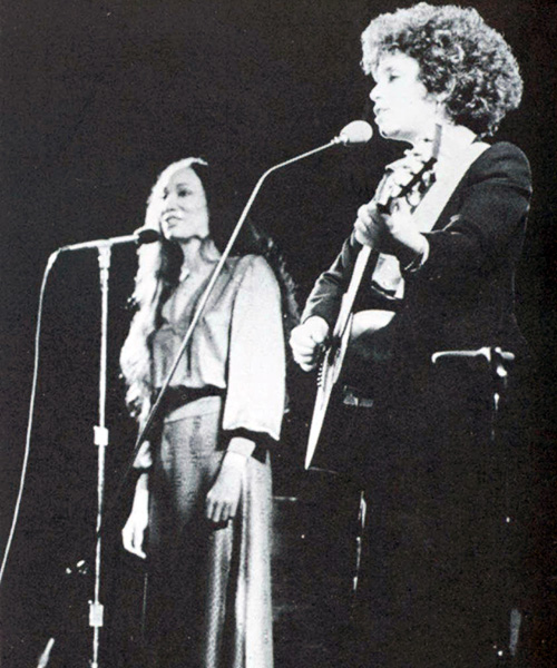 A vintage photo shows two women performing music live on stage.