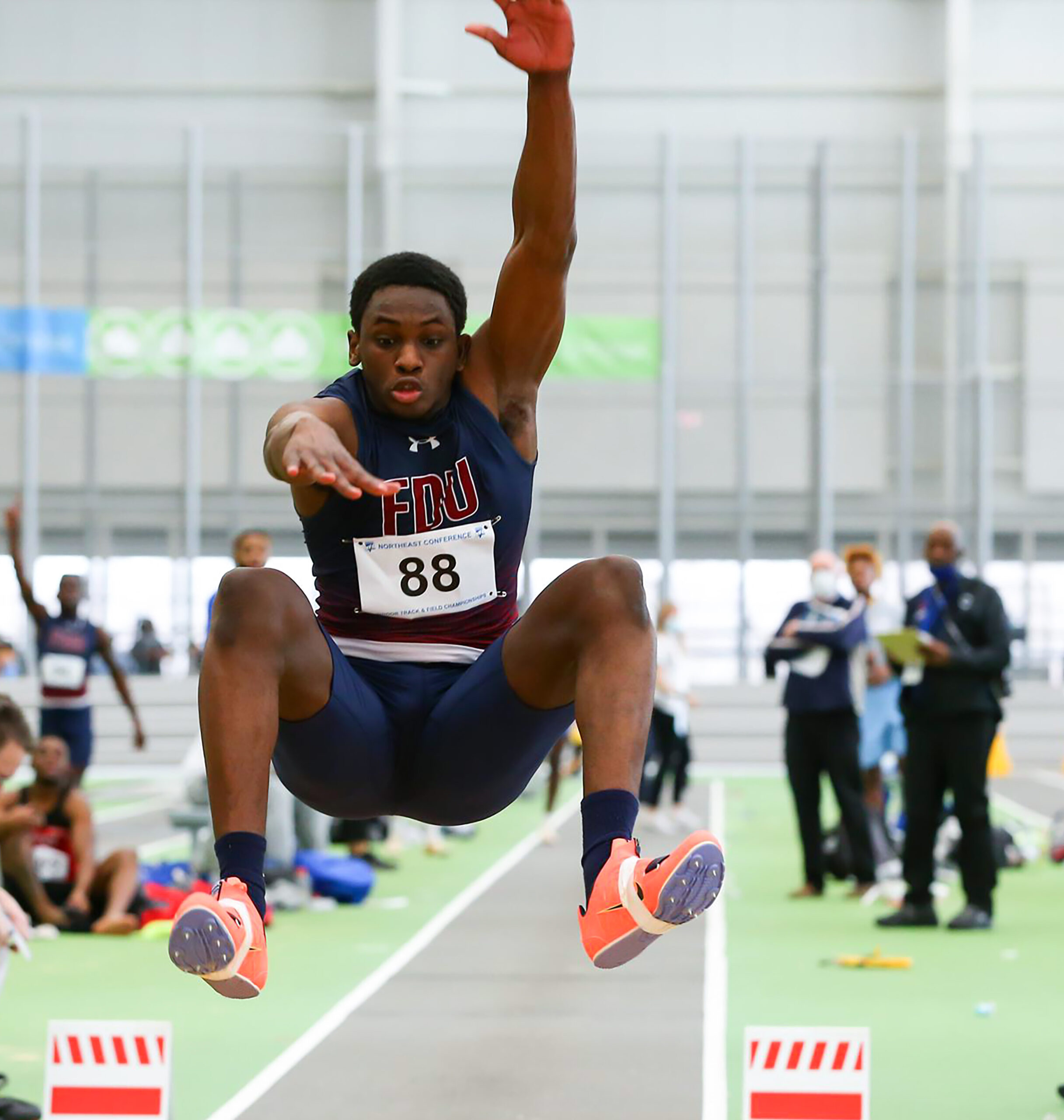 A young male triple jumper catches air during a meet.