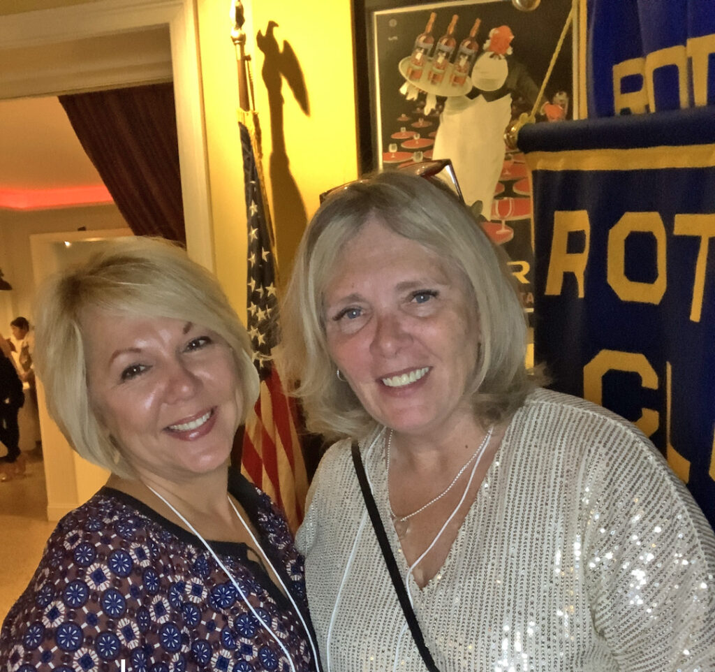 Two women with blonde hair pose together for a photo. 