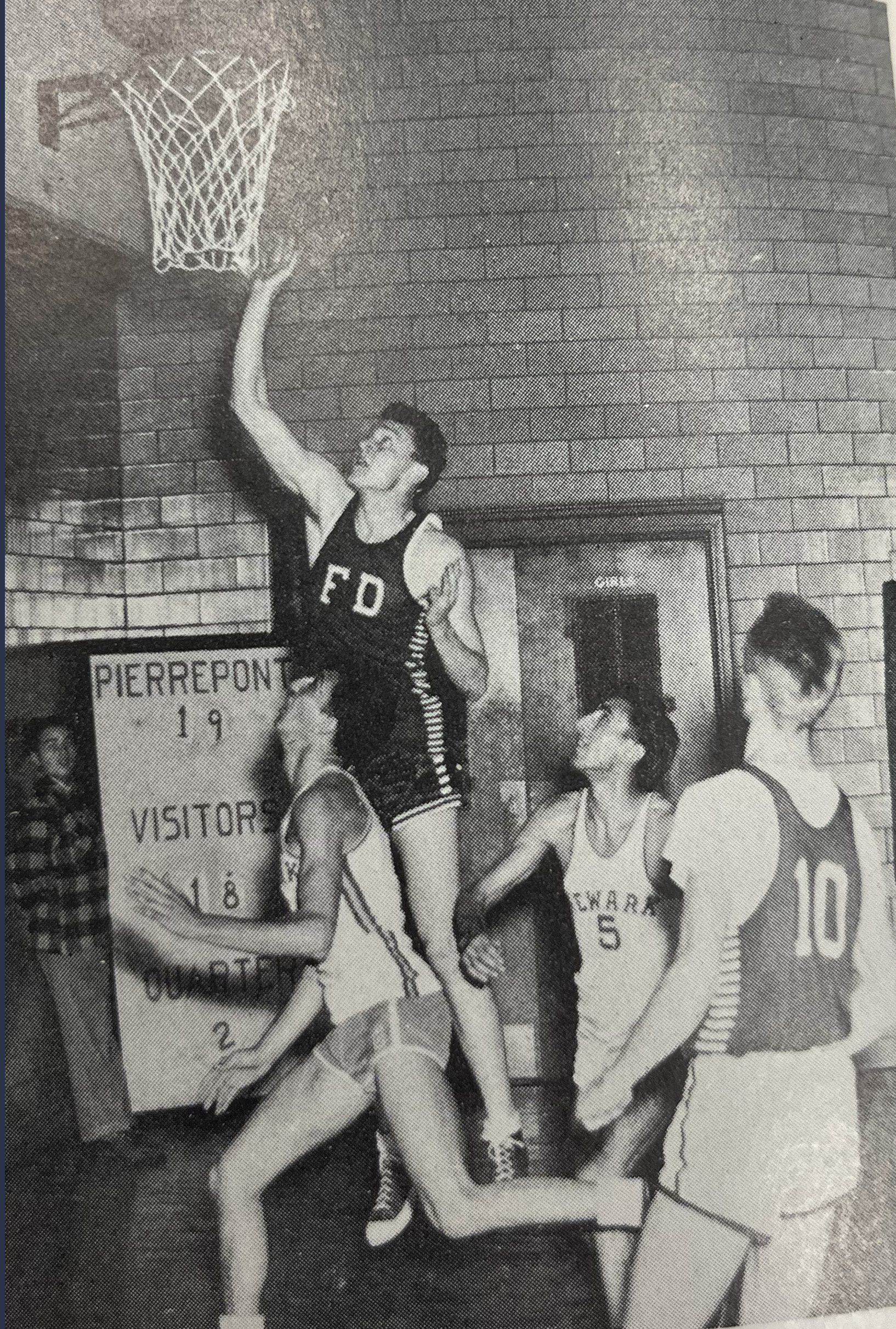 A man goes up for a layup shot while playing basketball. 