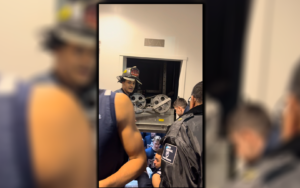 a screenshot from a video. firefighters help student-athletes out of an elevator