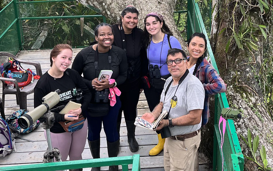 A group of students and research equipment in a tropical location.