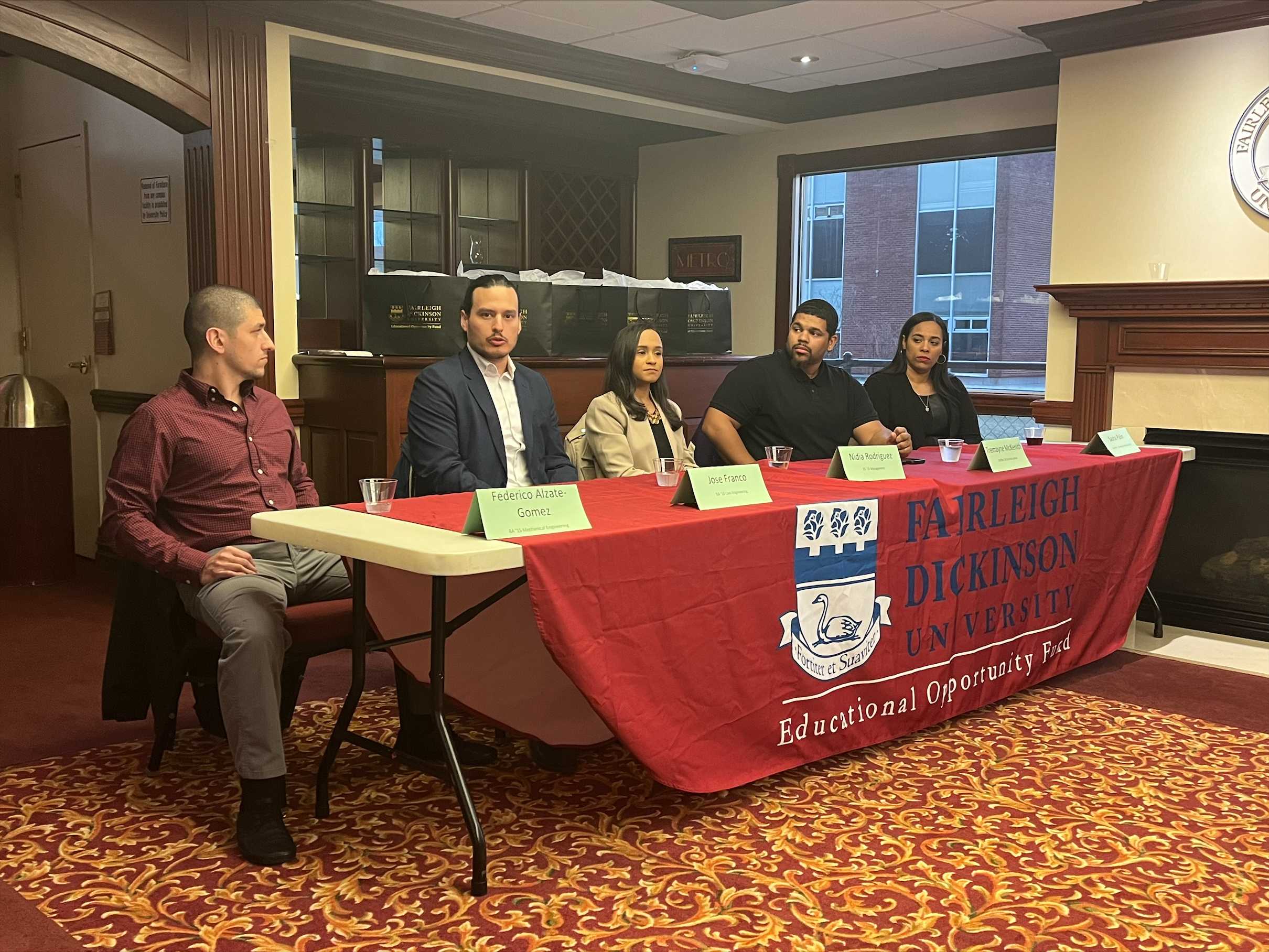 a group of people sit on one side of a table. they have name tags and the table has a "Fairleigh Dickinson University Educational Opportunity Fund" tablecloth.