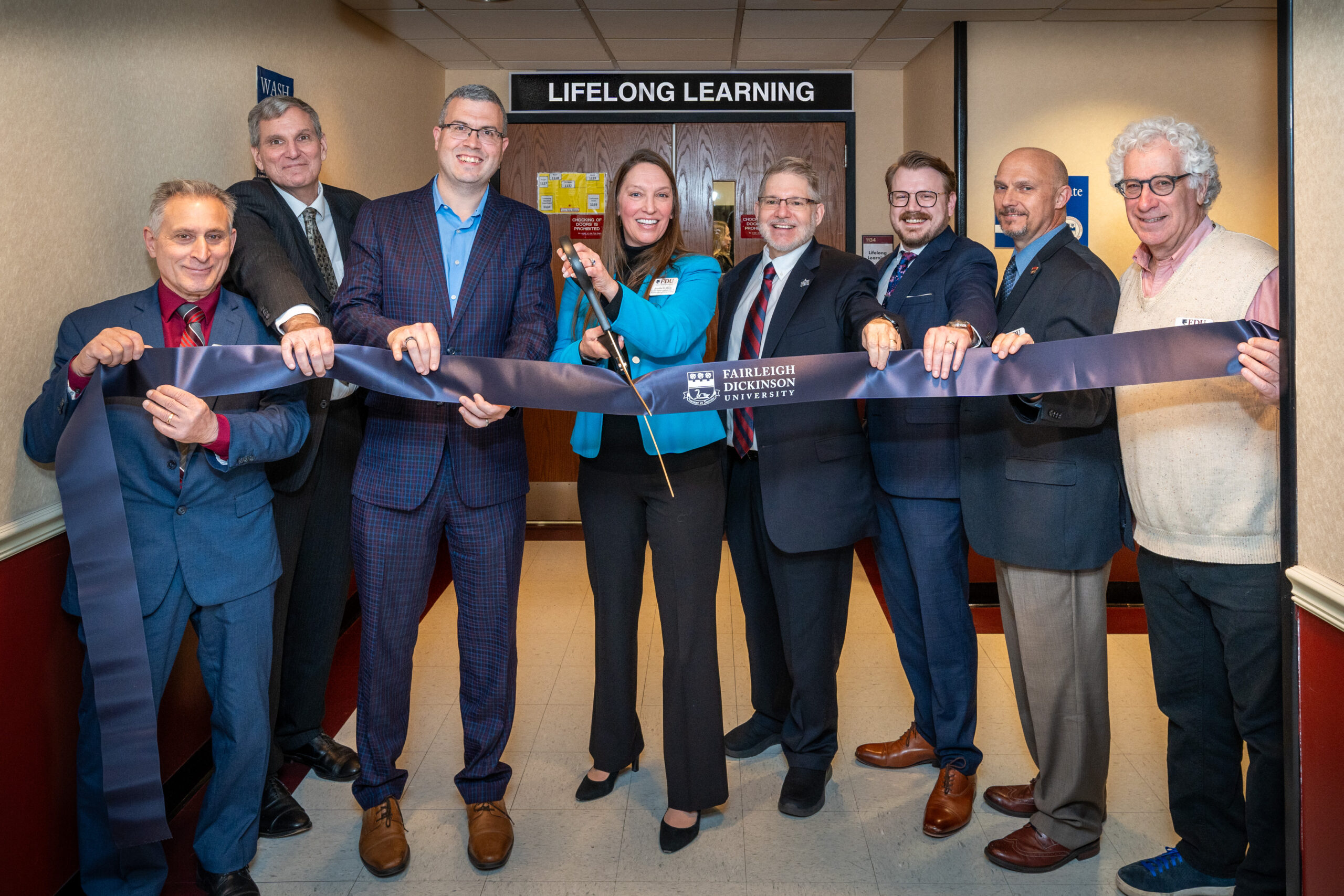 people posed with a ribbon at official event