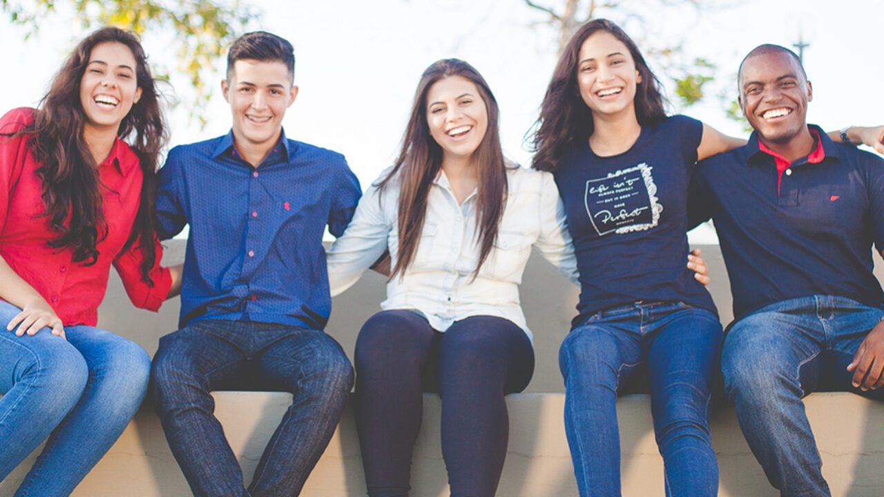 a group of students siting and smiling at the camera