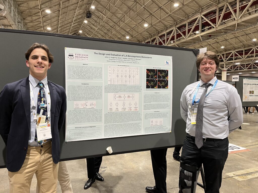 a student and professor stand in front of a presentation board