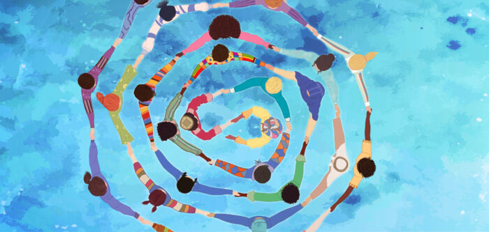 An overhead view of multicultural people. They are in concentric circles, holding hands, against an abstract blue background.