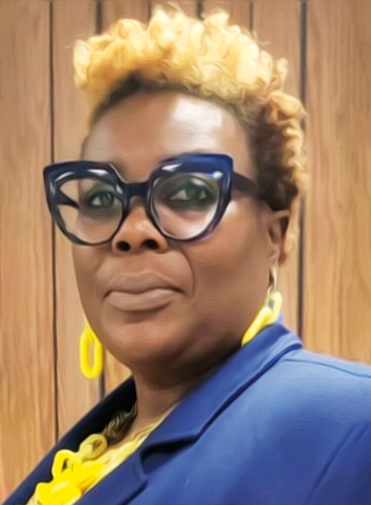 A woman with short hair, glasses and yellow jewelry smiles for a photo.