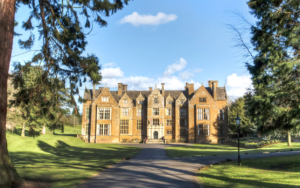 a pathway leads to the Wroxton Abbey, surrounded by trees.
