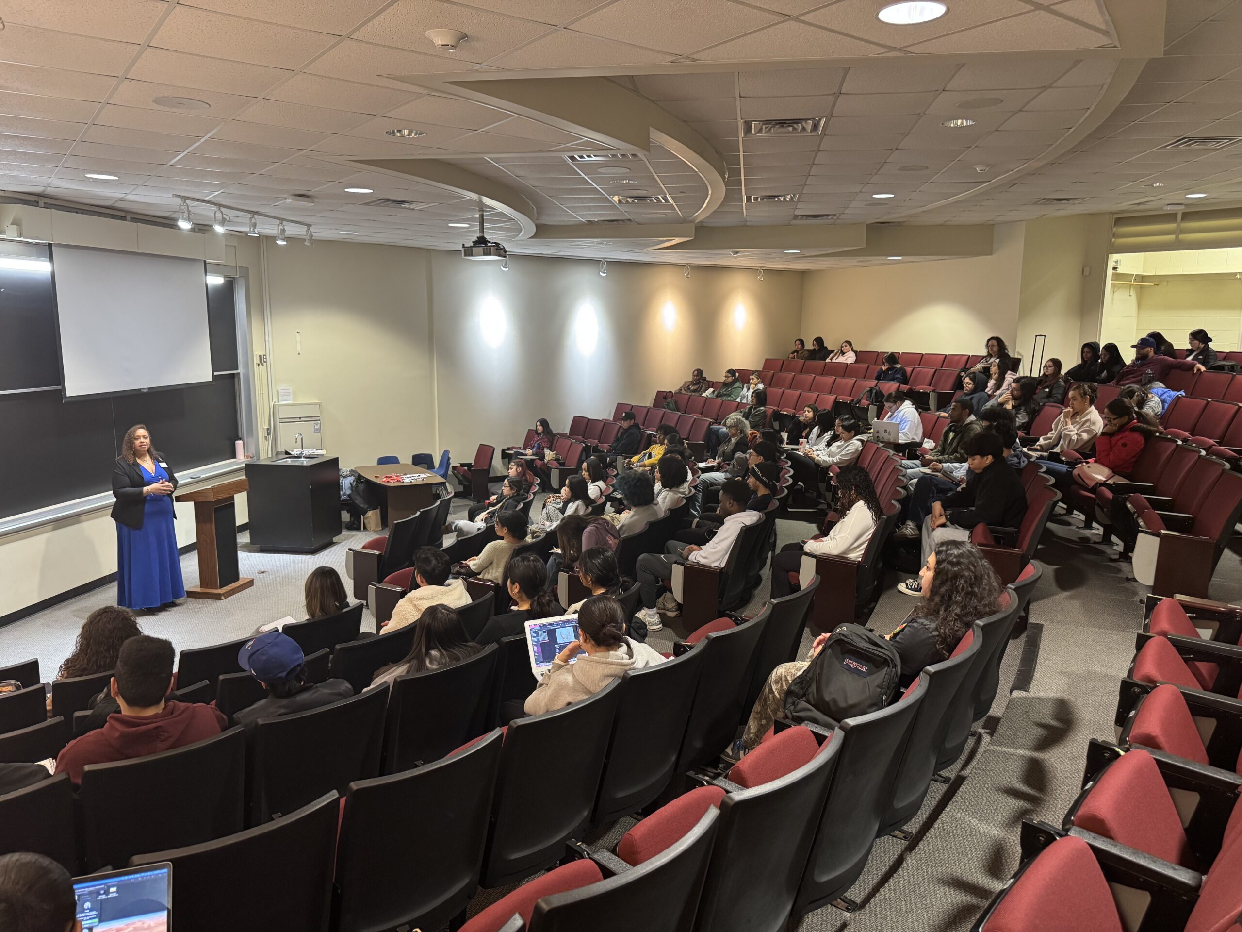 A speaker talks to an auditorium of people