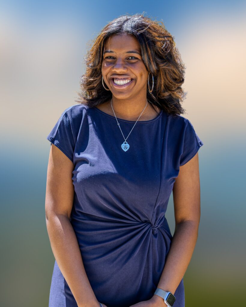 headshot of a woman. she wears a blue dress.