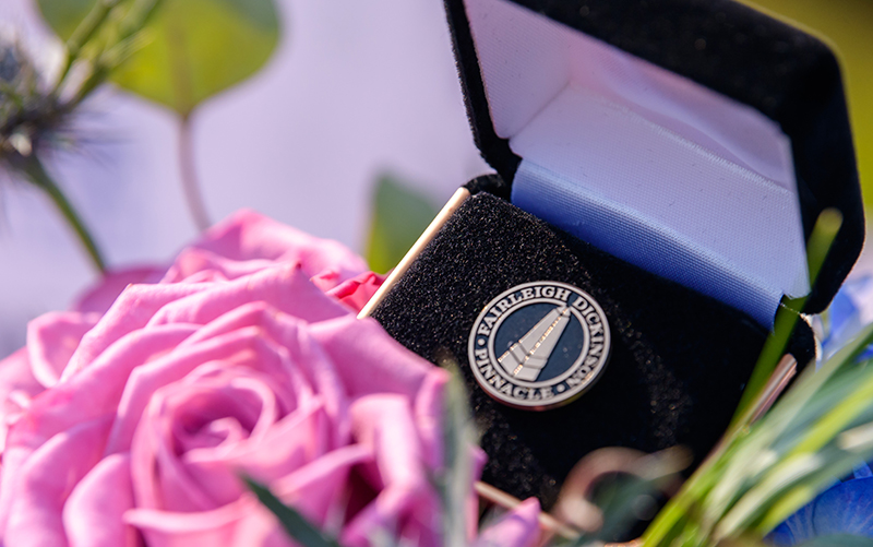 Close up of a flower arrangement and a pin on a table.