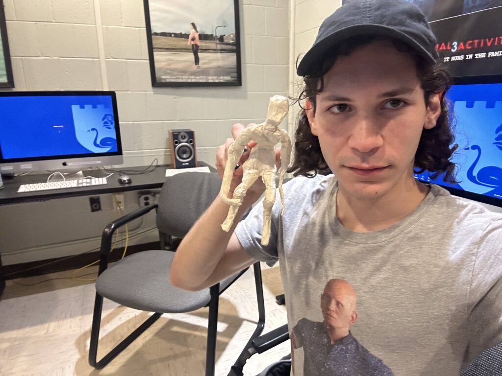 A man holds up a figurine.