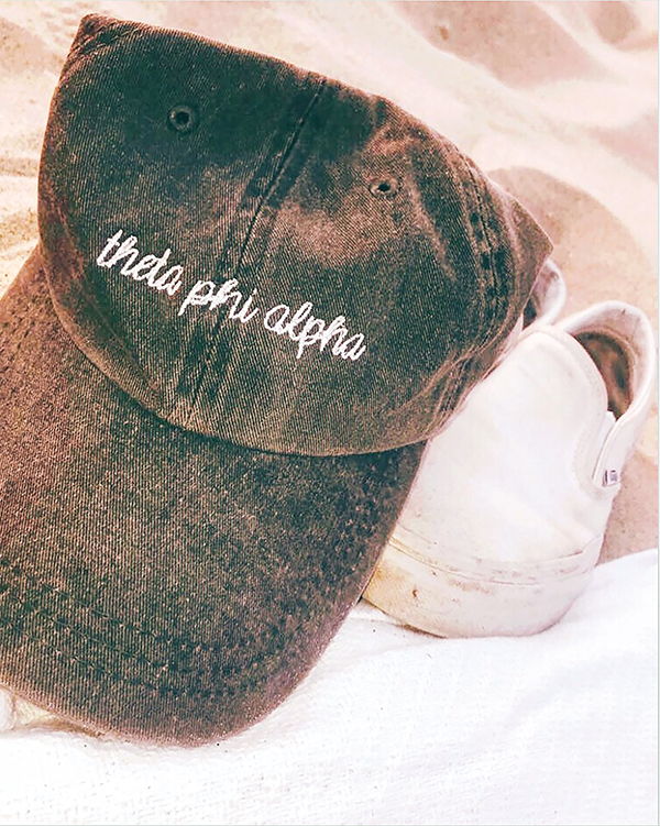 A baseball hat that reads theta phi alpha.