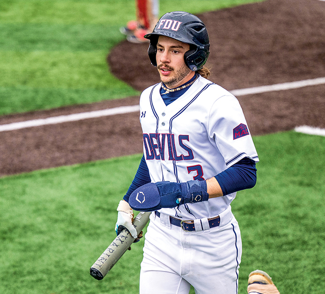 A man in a baseball uniform returns from the infield.