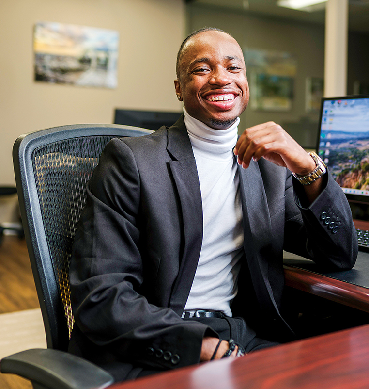 A young man sits at a desk in an accounting office.