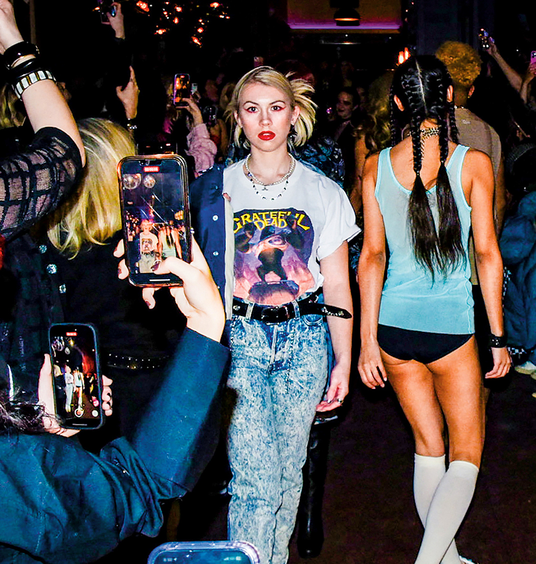 A young woman wearing vintage clothing walks in a fashion show.