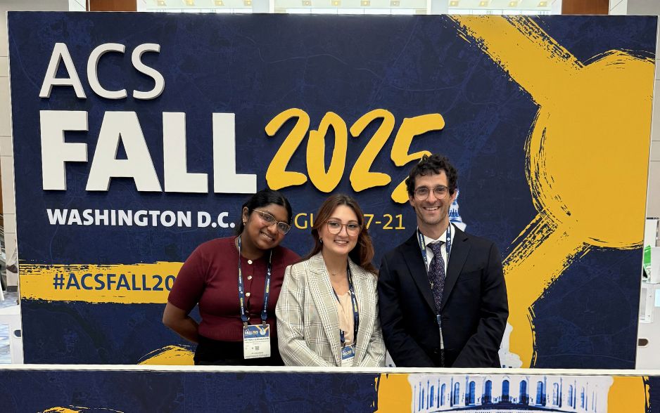 two college students and a professor smile and pose in front of a sign. the sign reads "ACS Fall 2025."