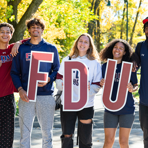 Five students pose for a photo with the FDU letters.