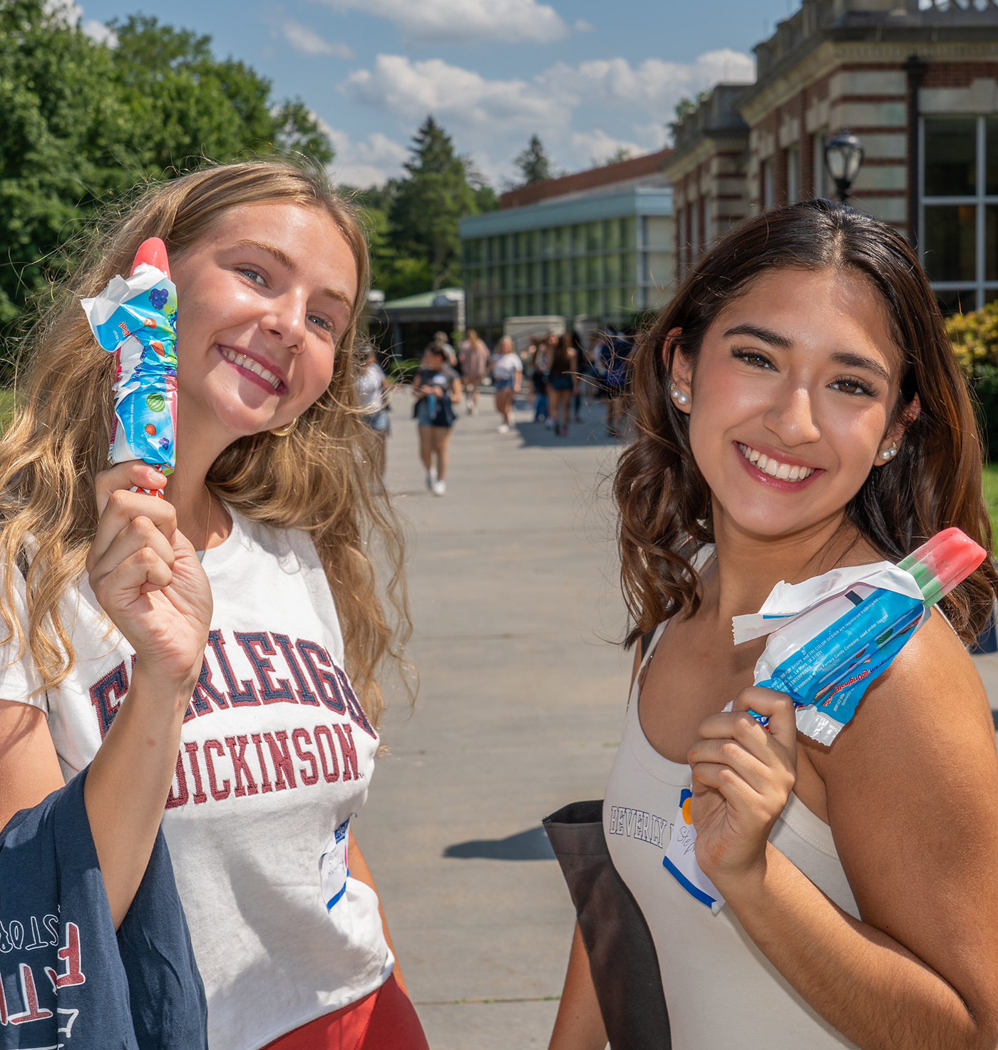 Two students hold up their ice pops at a campus event.