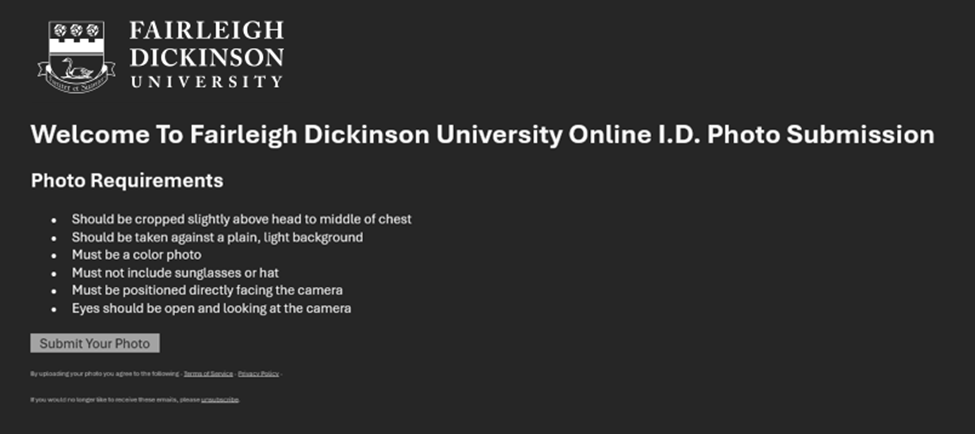 Screenshot of Fairleigh Dickinson University’s online ID photo submission webpage. At the top left is the university’s logo with the name “Fairleigh Dickinson University.” The main heading reads: “Welcome To Fairleigh Dickinson University Online I.D. Photo Submission.” Beneath is a section titled “Photo Requirements” with a bulleted list: Should be cropped slightly above head to middle of chest Should be taken against a plain, light background Must be a color photo Must not include sunglasses or hat Must be positioned directly facing the camera Eyes should be open and looking at the camera Below the list is a gray button labeled “Submit Your Photo.” At the bottom, small text notes that by uploading a photo the user agrees to terms of service and privacy policy, along with an unsubscribe link. The background is dark gray with white text.