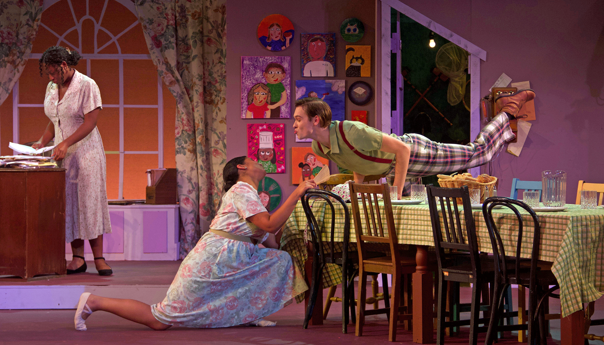 Three students perform on stage.