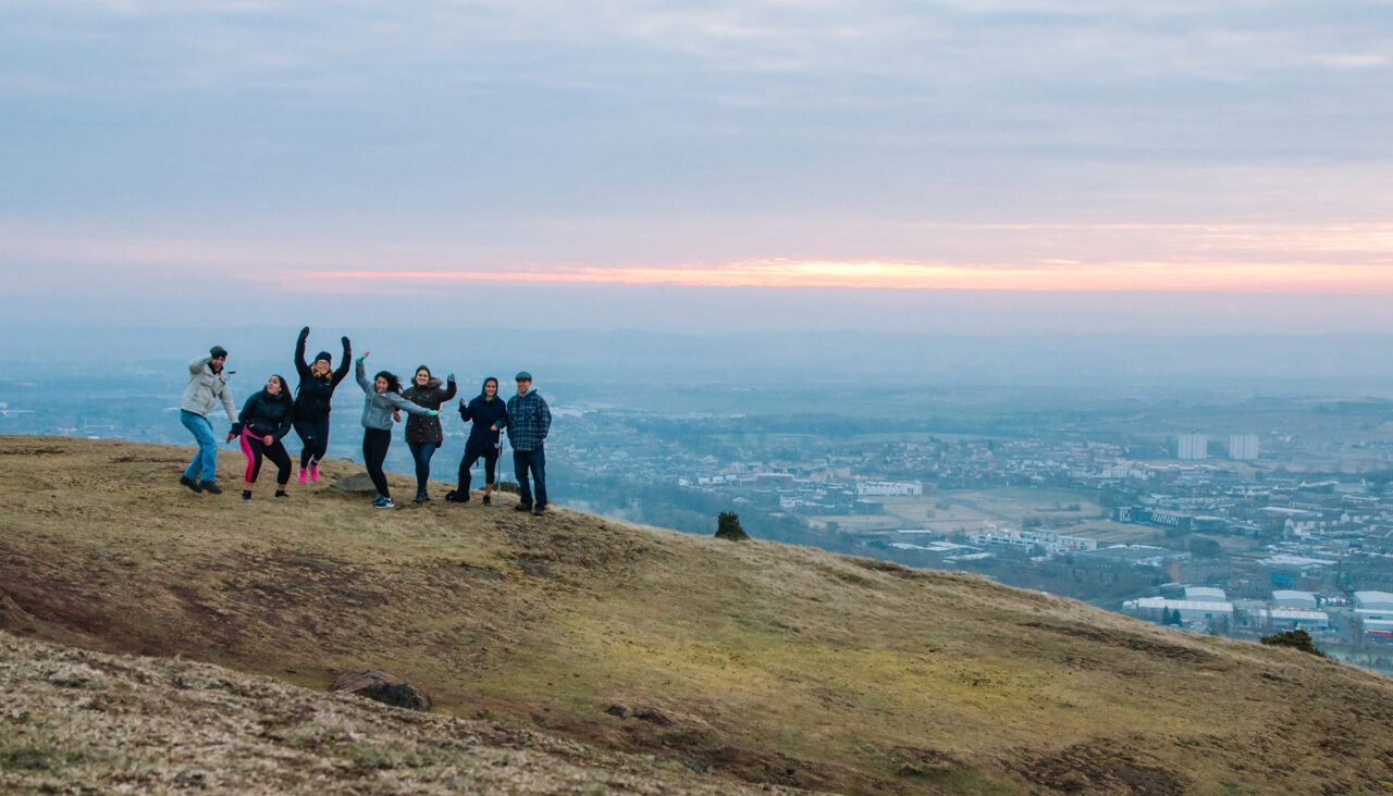 A group of students stand on a mountain abroad.