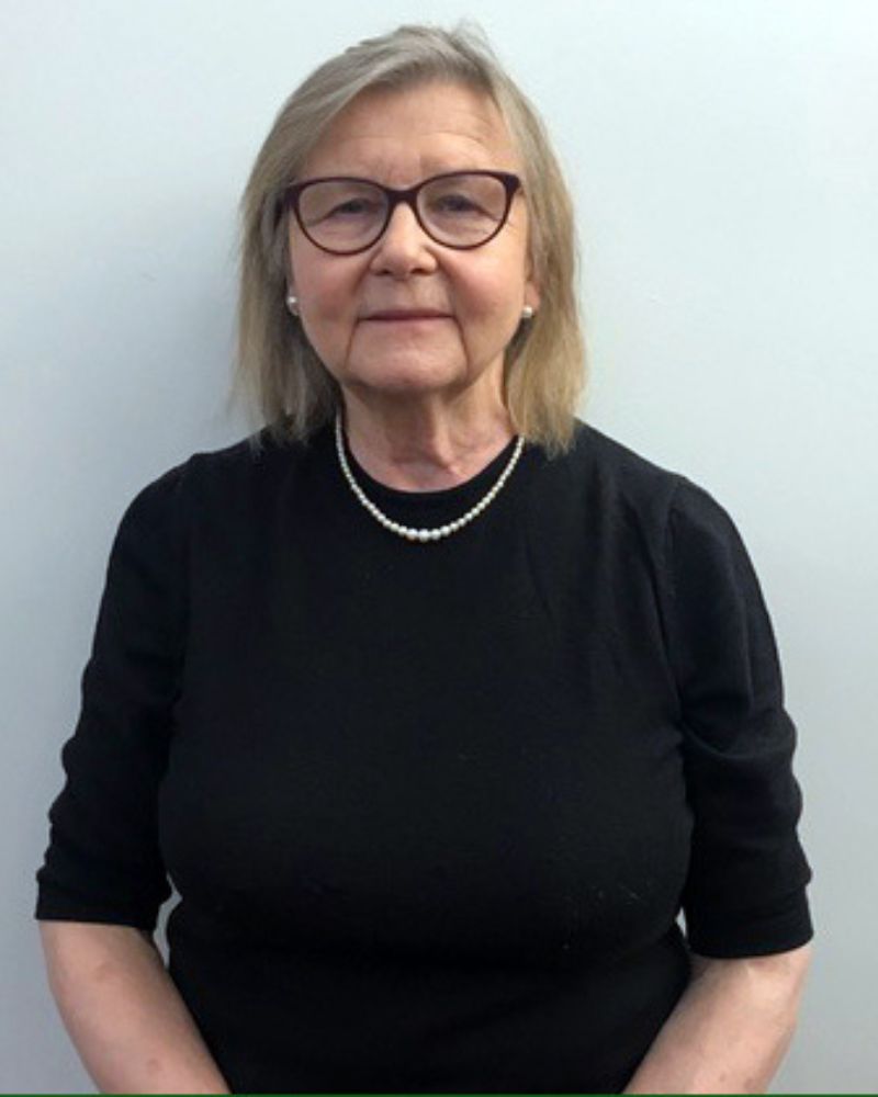 a portrait of a woman. she wears a black top.