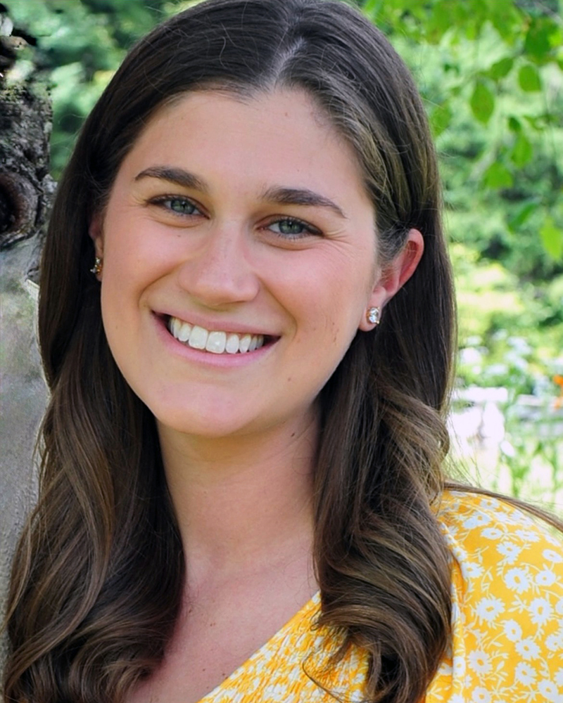 a portrait of a woman. she stands outside.