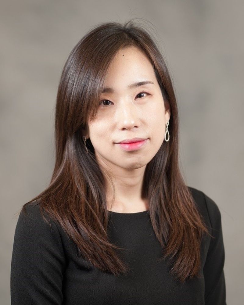 a portrait of a woman. she wears a black top.