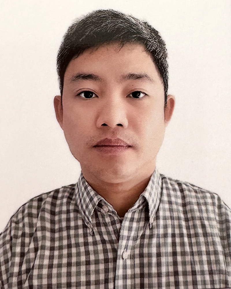 a portrait of a man. he wears a black and white button-down shirt.