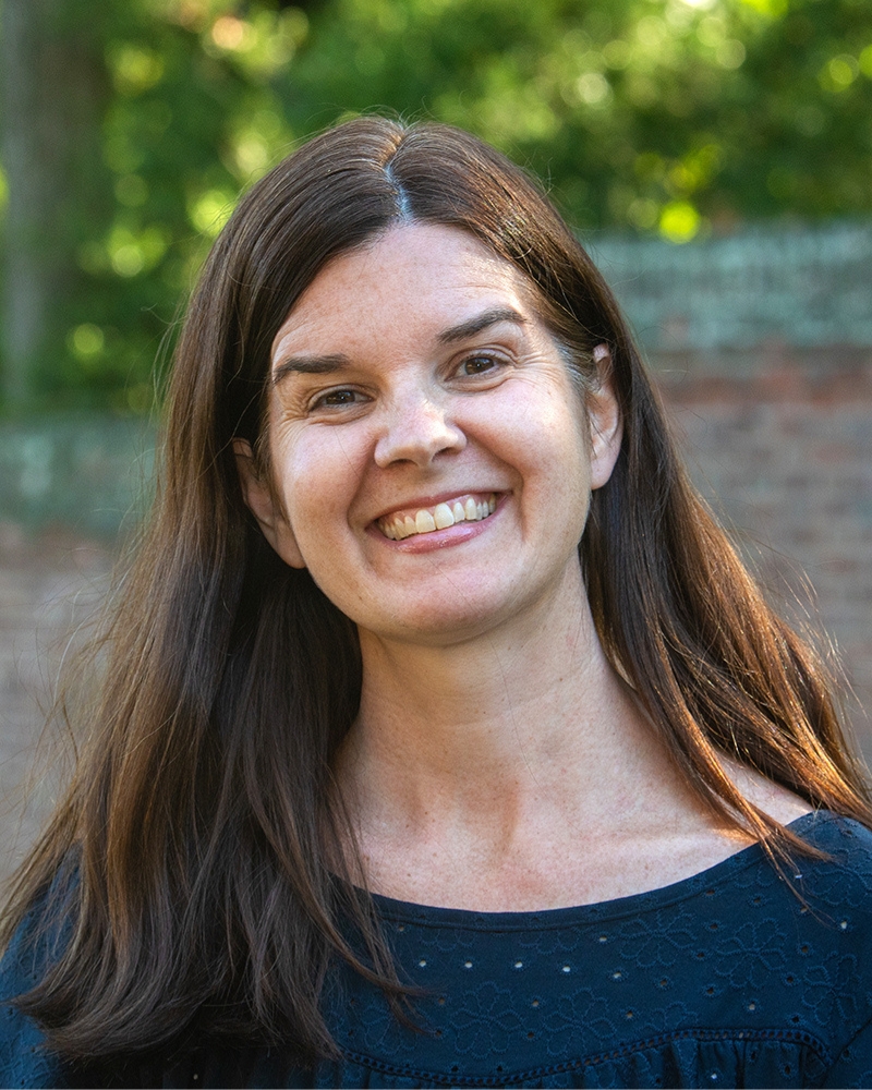 a portrait of a woman. she stands outside.