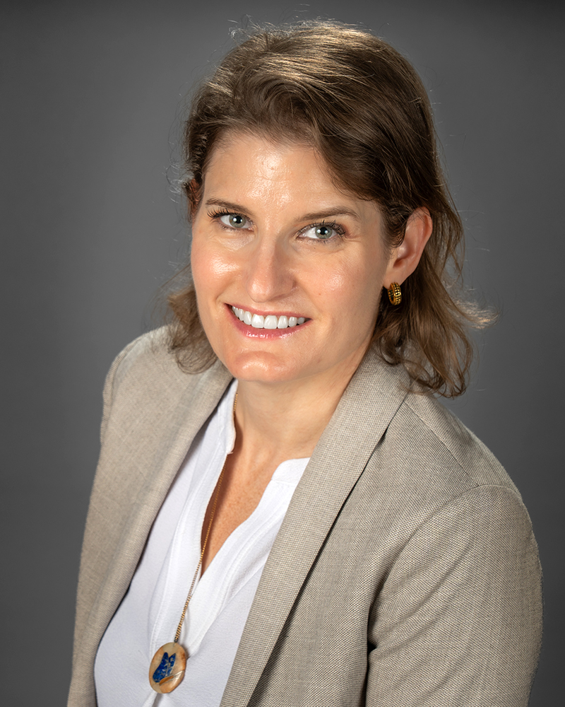 a portrait of a woman. she wears a beige blazer.
