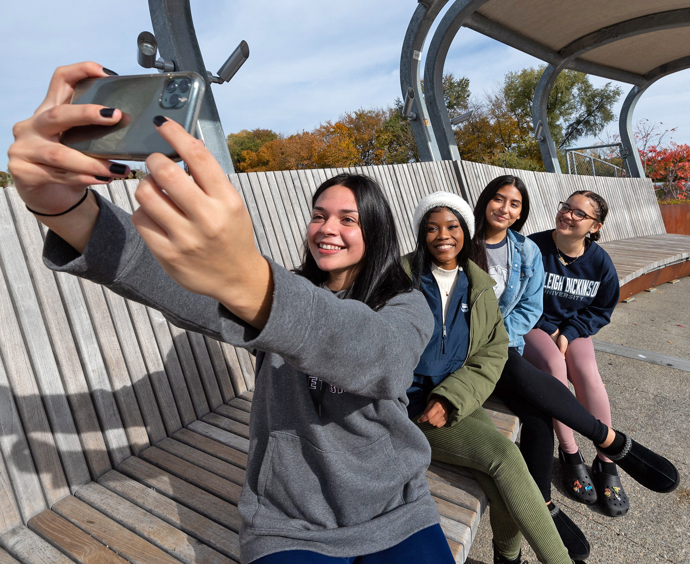 A group of students take a selfie on the footbridge of the Metropolitan Campus.