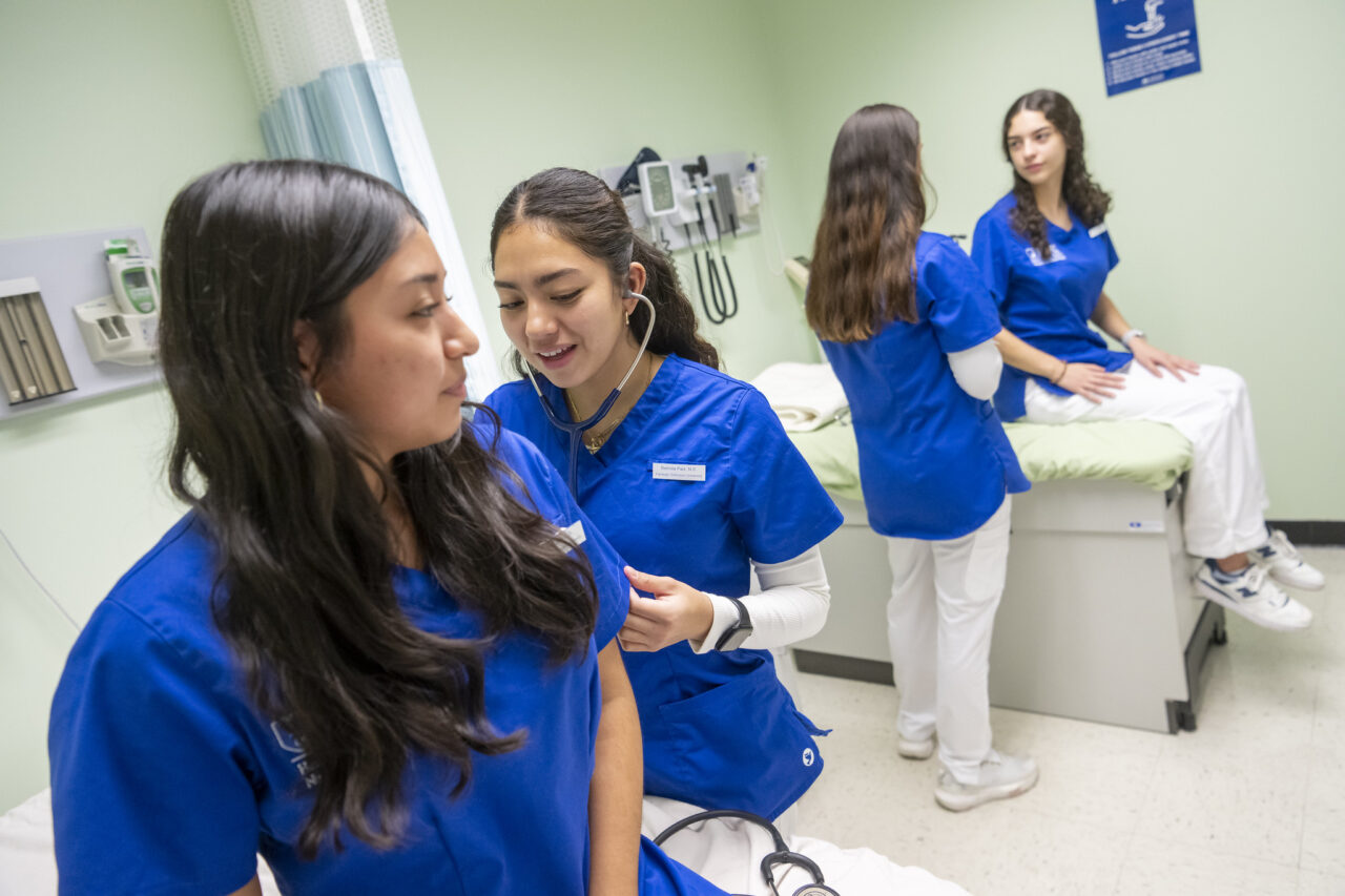 Nursing students practice taking one another's vital signs.