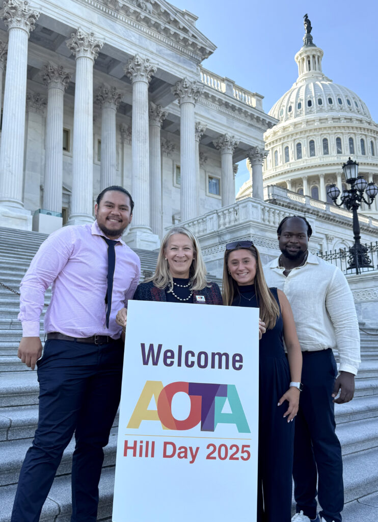Four people holding AOTA banner in front of the U.S. Capitol